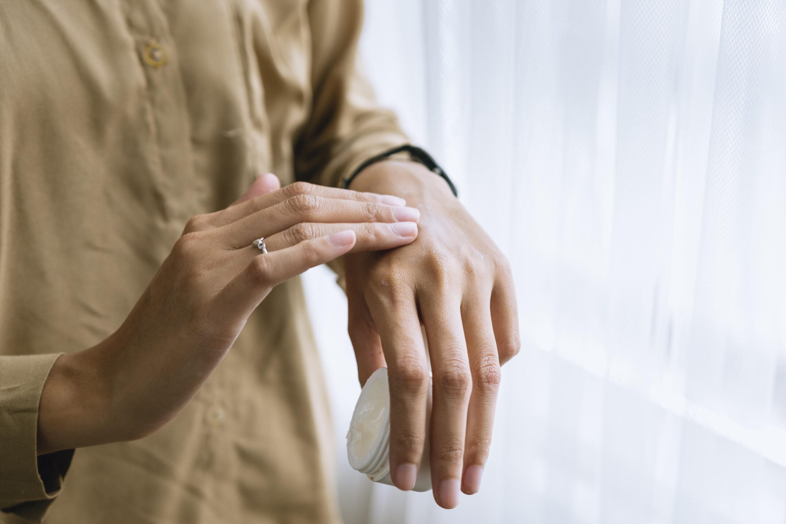 Person applying cream to the back of their hand